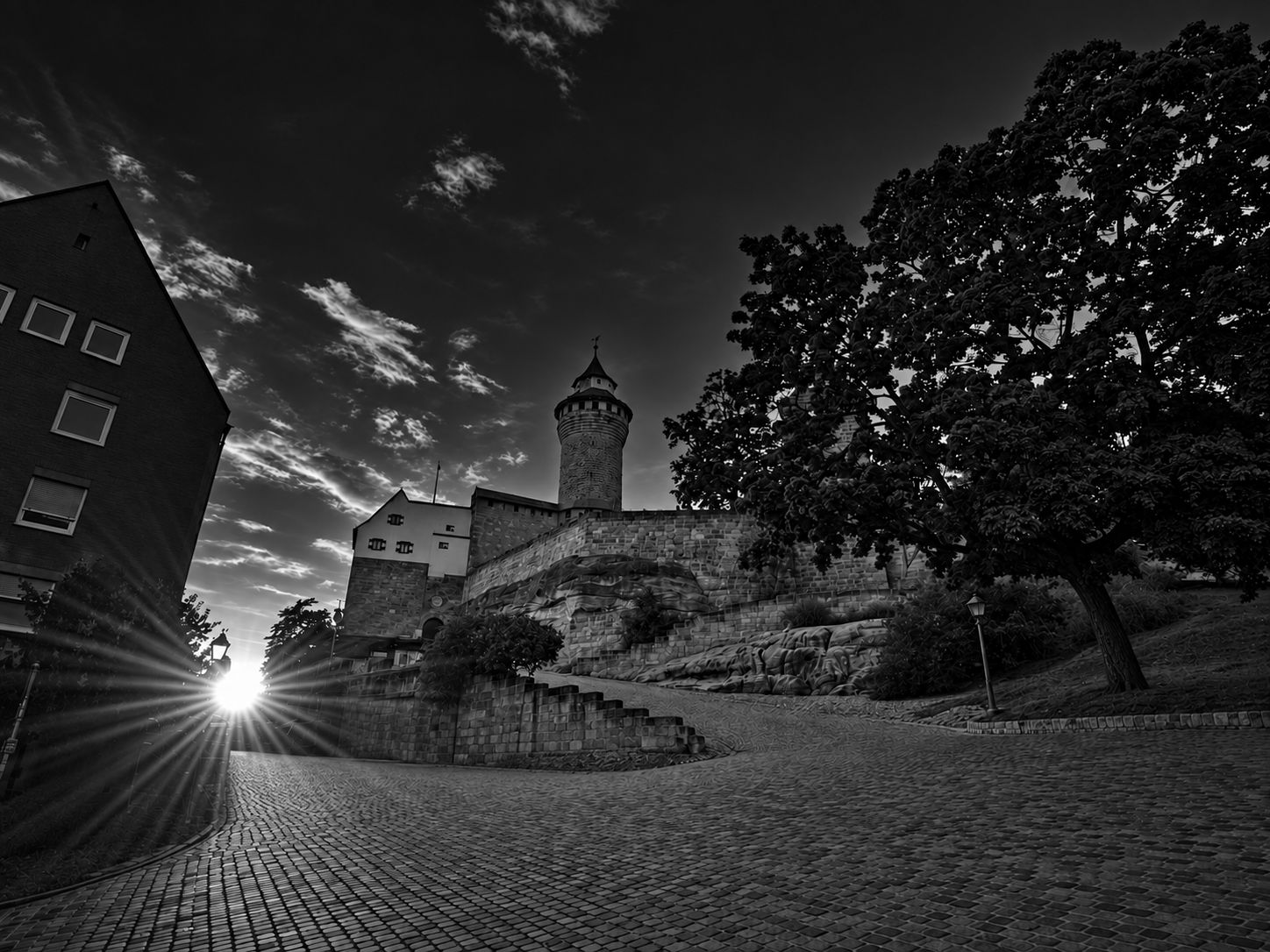 Nürnberger Kaiserburg im Gegenlicht, leerer Platz ohne Menschen und Autos in dunklem Schwarz-Weiß